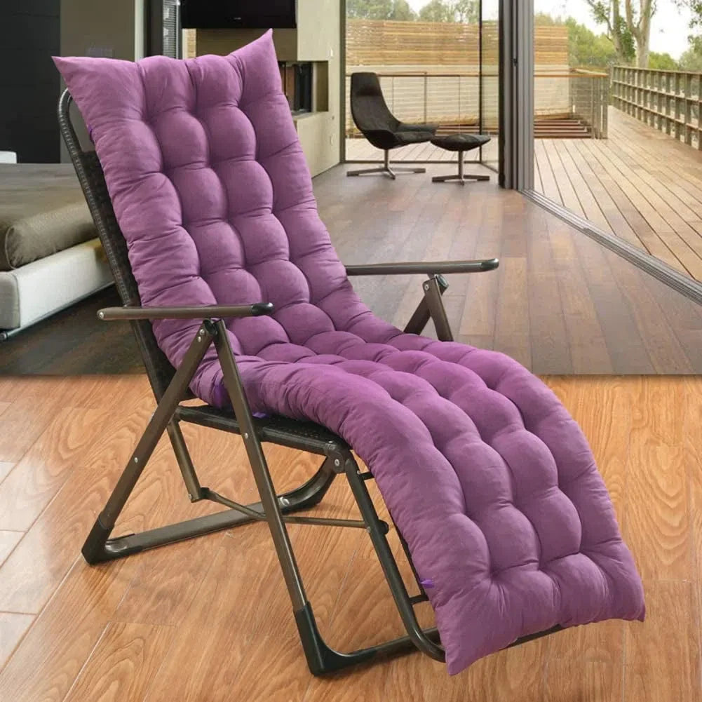Coussin de chaise longue capitonné violet installé sur un fauteuil relax pliant, dans un salon ouvert sur une terrasse
