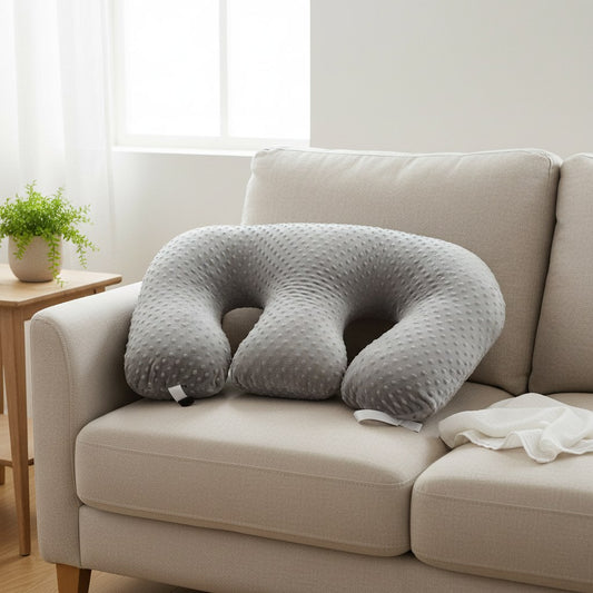Coussin d'allaitement pour jumeaux gris posé sur un canapé