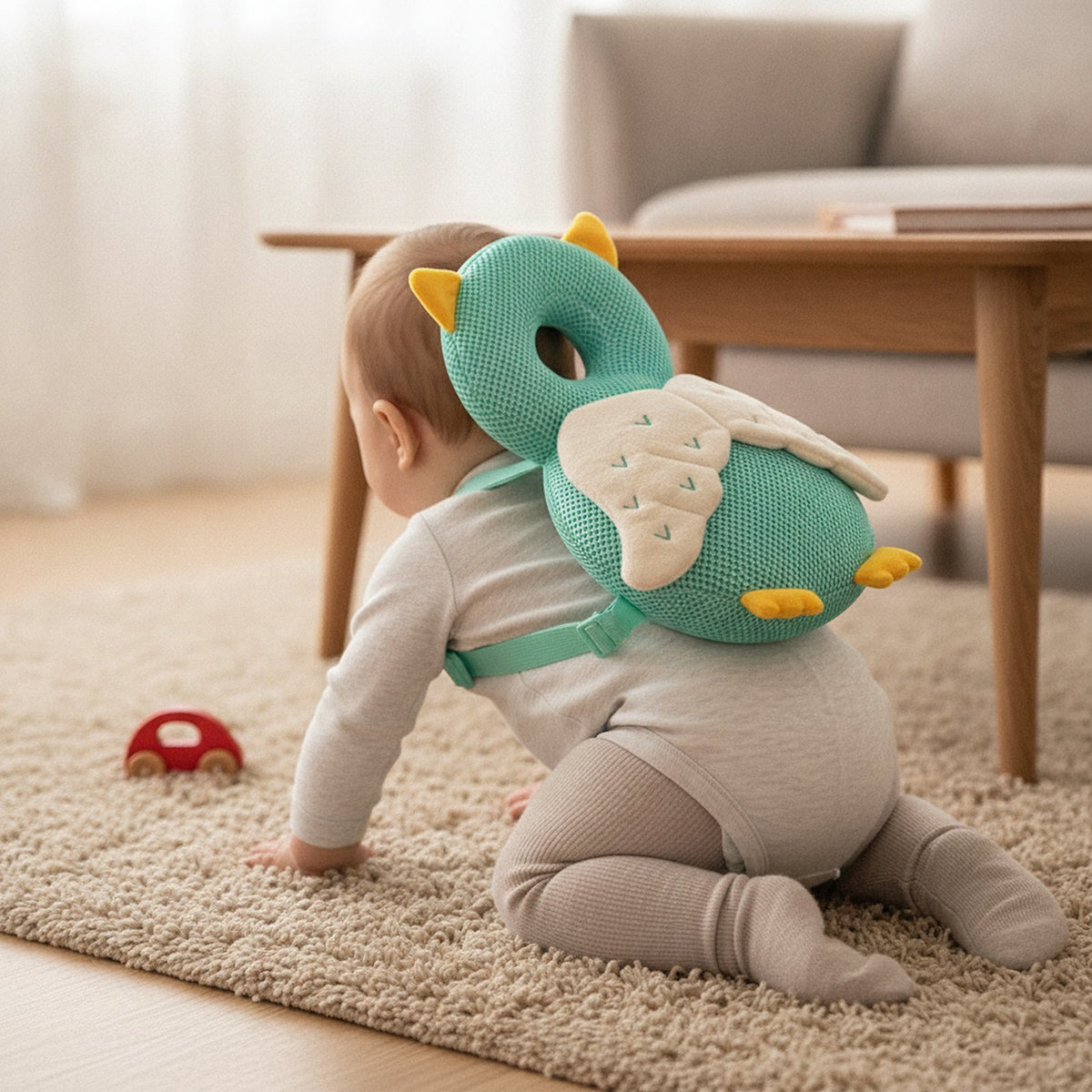 Bébé à quatre pattes sur un tapis avec le coussin anti-chute Hibou sur le dos
