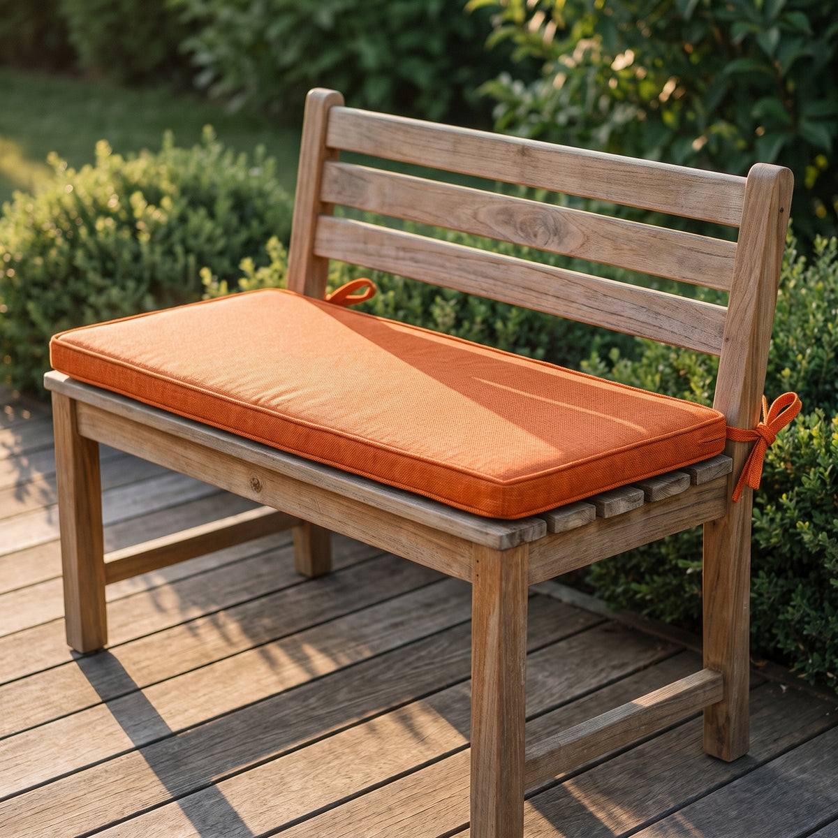Coussin pour banquette d'extérieur orange, 3 cm d'épaisseur avec attaches, posé sur un banc de jardin en bois
