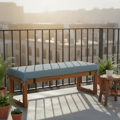 Coussin pour banquette d'extérieur bleu ciel attaché sur un banc de jardin en bois, balcon
