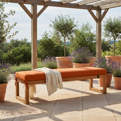 Coussin pour banquette d'extérieur orange attaché sur un banc de jardin en bois, terrasse ensoleillée