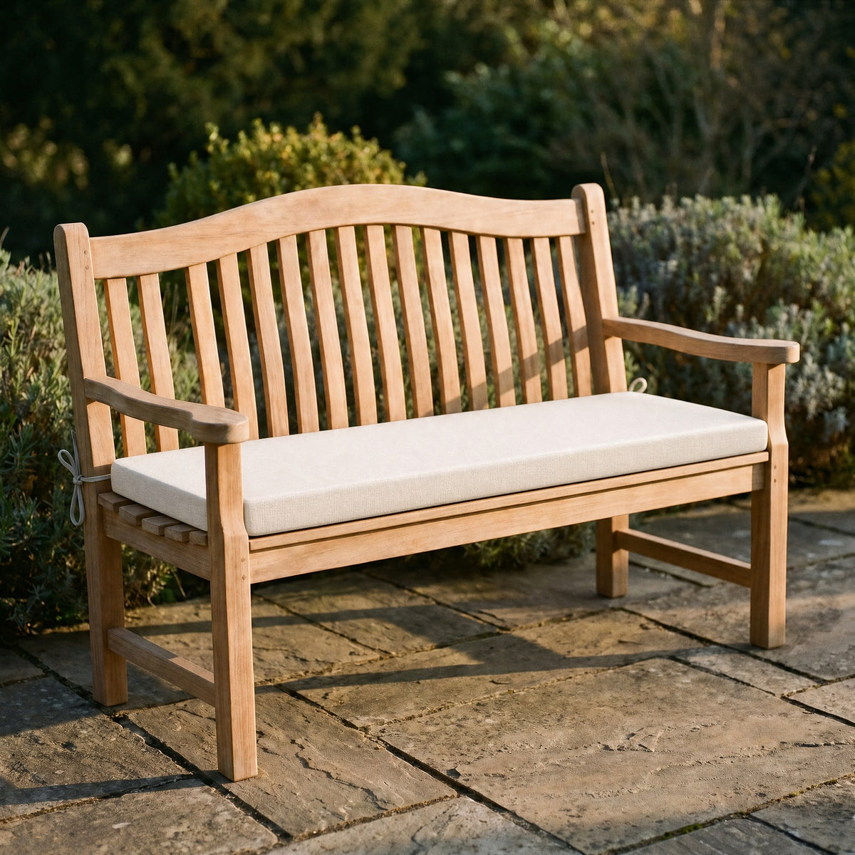 Coussin de banquette sur mesure en polyester coloris riz, coussin plat avec cordons d'attache, posé sur un banc de jardin en teck