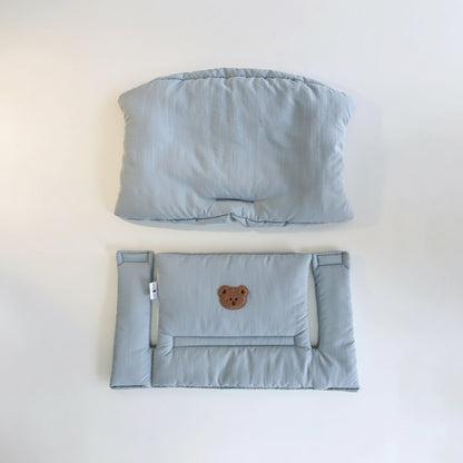 Les deux parties du coussin de chaise haute évolutive bleu : dossier et assise avec un petit ours brodé
