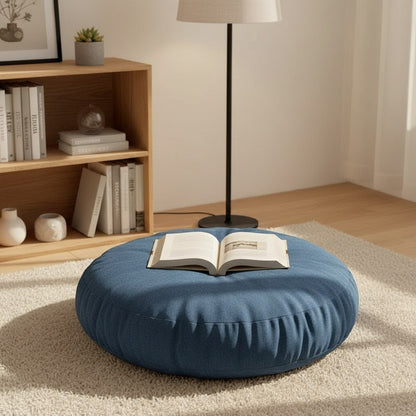 Coussin de sol bleu dans un coin lecture, un livre posé dessus
