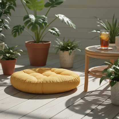 Coussin de sol rond en velours côtelé jaune sur une terrasse couverte