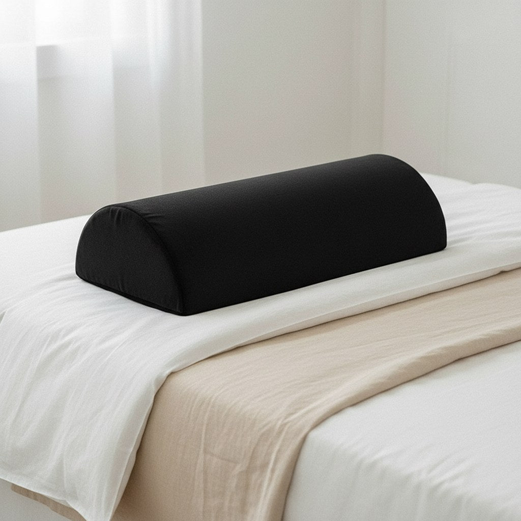 Coussin demi-lune posé sur le lit pour soulager les genoux