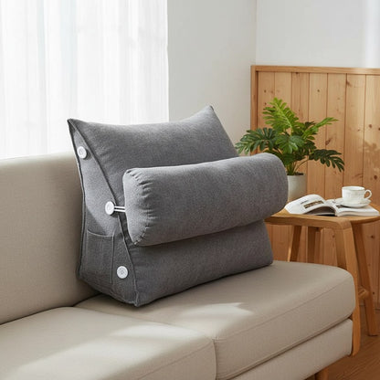 Coussin de dossier triangulaire gris avec appui-nuque, calé contre l'accoudoir d'un canapé