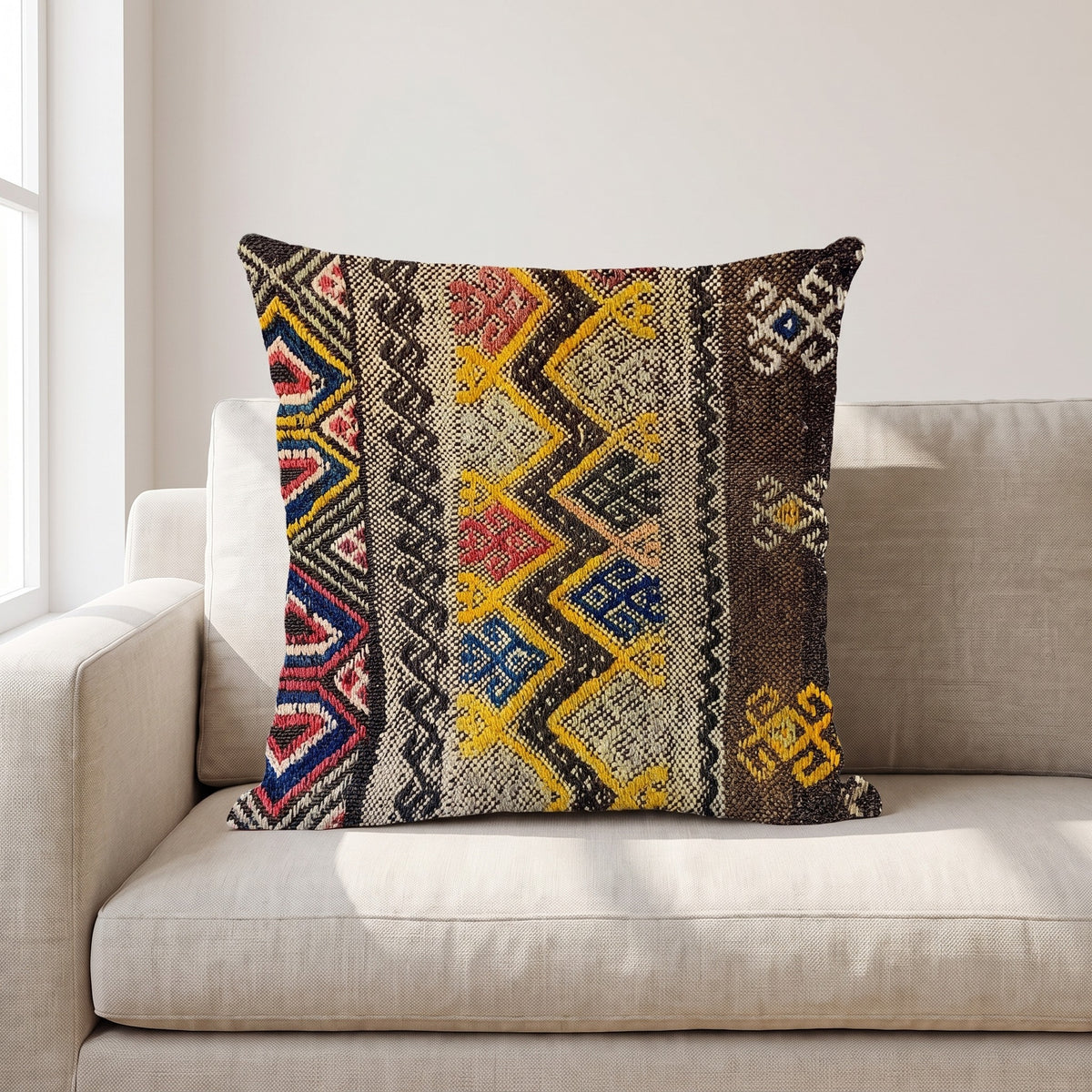 Coussin ethnique motif Chants Aborigènes 45x45 cm posé sur un canapé en lin beige