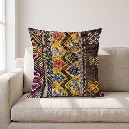 Coussin ethnique motif Chants Aborigènes 45x45 cm posé sur un canapé en lin beige