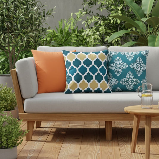 Housses de coussin extérieur imperméables motifs Uni orange, Arabesque bleu et jaune et Médaillon bleu canard sur un canapé de jardin en teck, terrasse ensoleillée