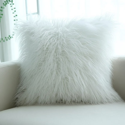 Poils longs et ondulés d'un coussin en fausse fourrure blanche posé dans un fauteuil