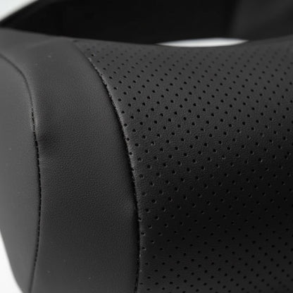 Détail du simili cuir noir perforé et des coutures du coussin de nuque