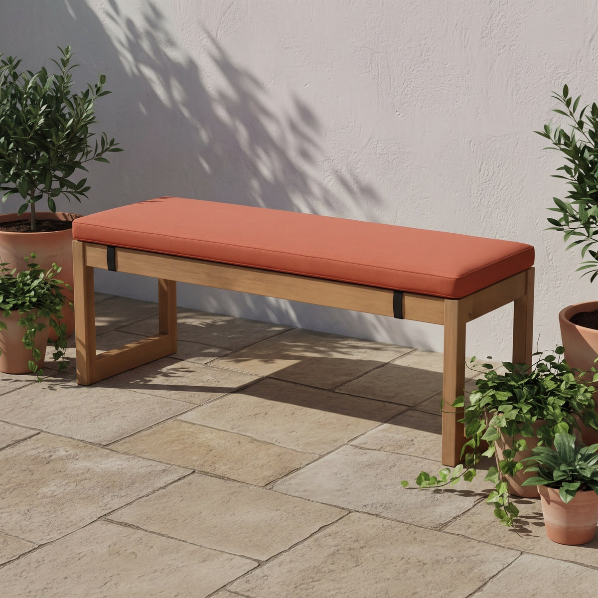 Coussin pour banc orange de 3 cm d'épaisseur sur un banc de jardin en teck, en terrasse