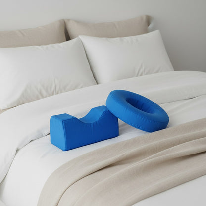 Coussin relève-jambe en U bleu posé sur un lit