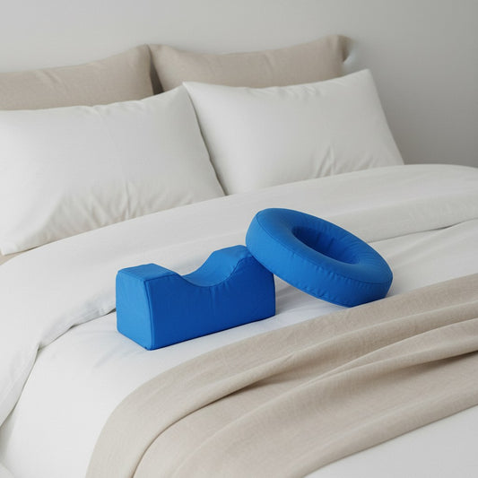 Coussin relève-jambe en U bleu posé sur un lit