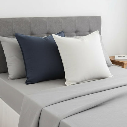 Coussins de lit 66 x 66 cm bleu marine et blanc sur un lit gris