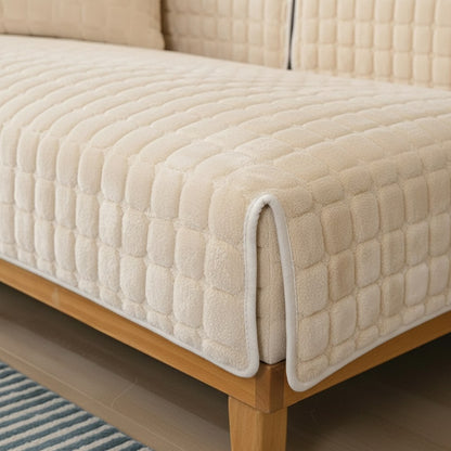 Détail du velours matelassé crème d'une housse de canapé, coin replié sur l'assise
