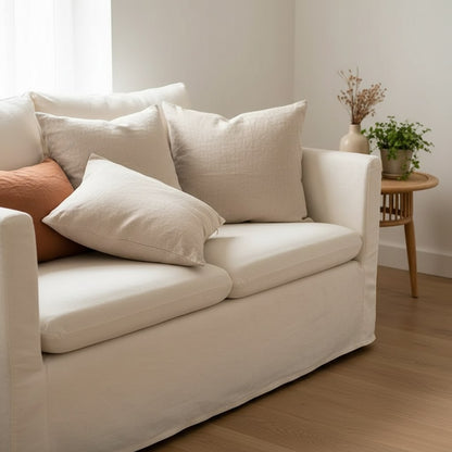 Coussins en lin naturel et terracotta sur un canapé blanc