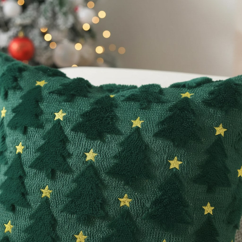 Détail des sapins en relief et des étoiles dorées d'une housse de coussin de Noël verte