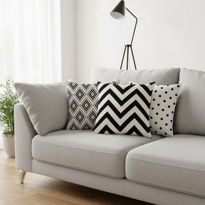 Housses de coussin noir et blanc à chevrons, losanges et pois sur un canapé gris clair