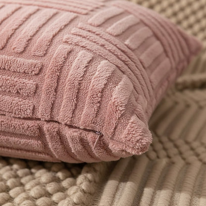 Détail du relief tressé et de la fermeture éclair d'une housse de coussin rose poudré