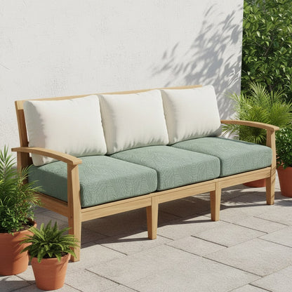 Housses extensibles vert sauge sur les coussins d'assise d'un canapé de jardin en teck, en terrasse