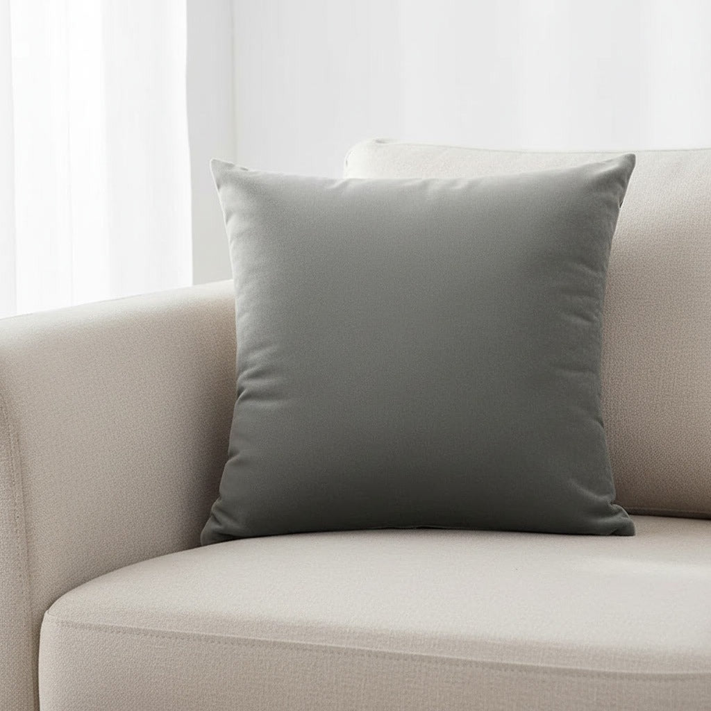Housse de coussin en velours gris 45x45 cm posée sur un canapé en lin beige