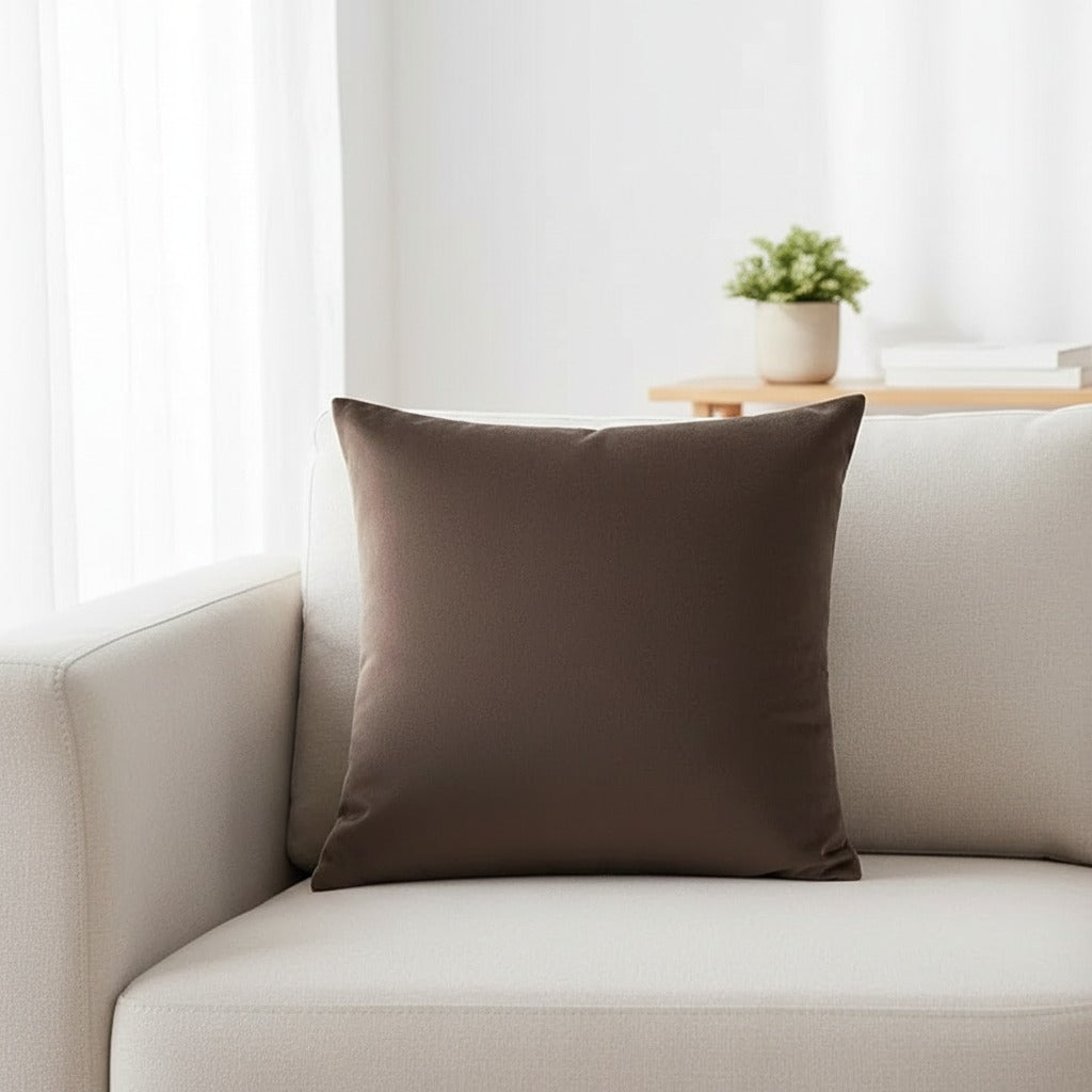 Housse de coussin en velours marron 45x45 cm posée sur un canapé en lin beige