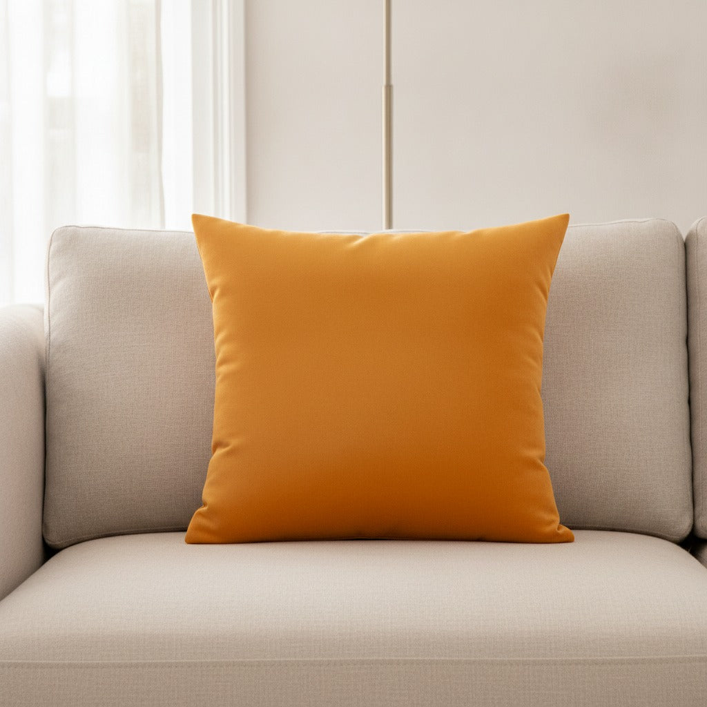 Housse de coussin en velours coloris Passion, orange doré 45x45 cm posée sur un canapé en lin beige
