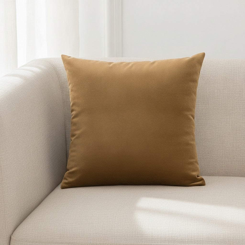Housse de coussin en velours taupe 45x45 cm posée sur un canapé en lin beige