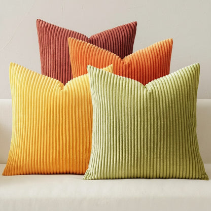 Les quatre housses de coussin en velours côtelé du lot terracotta, orange, moutarde et olive